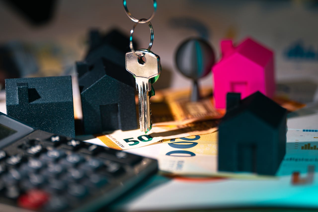 services-img A symbolic representation of real estate finance featuring keys, model houses, and euro banknotes.