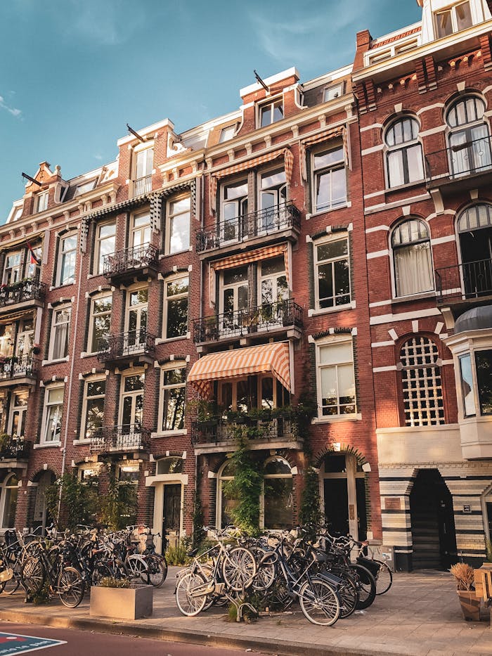 Classic Amsterdam building facade featuring bicycles on the street and European architectural style.