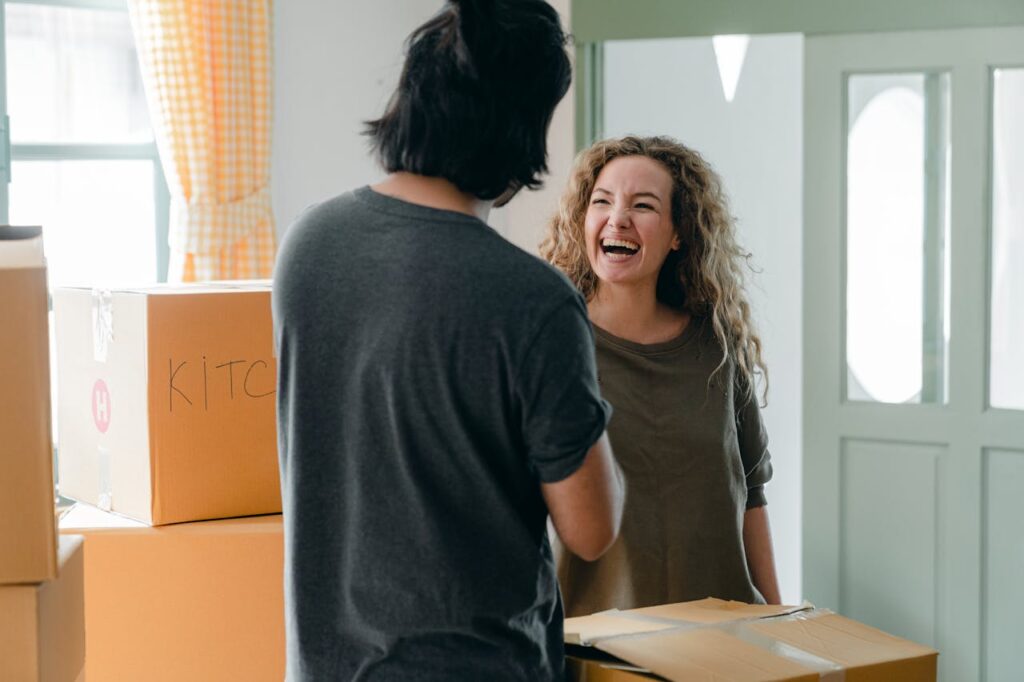 pexels photo 4246203 A joyful couple interacting with moving boxes in a bright living room, enjoying their new home.