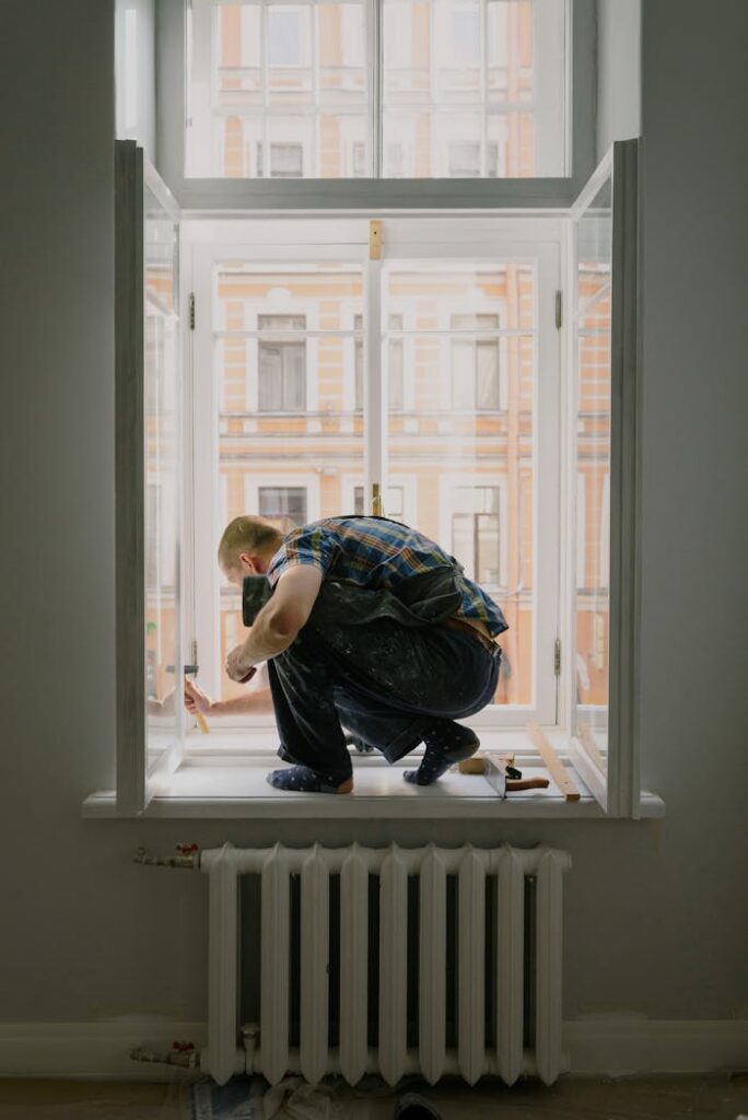 pexels photo 5691513 A handyman engaged in window repair work, focusing on craftsmanship.
